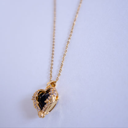 Gold necklace with a heart-shaped pendant on a light blue background