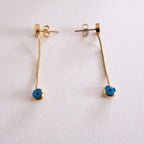 Two silver keychains with blue and white circular designs on a white background