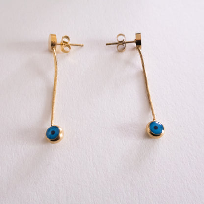 Two silver keychains with blue and white circular designs on a white background