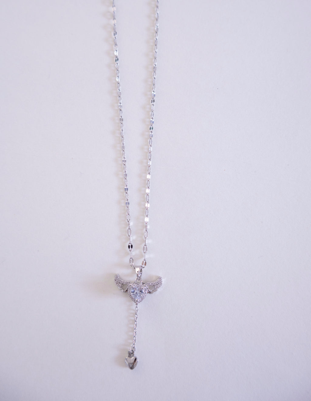 Silver necklace with a pendant on a light gray background