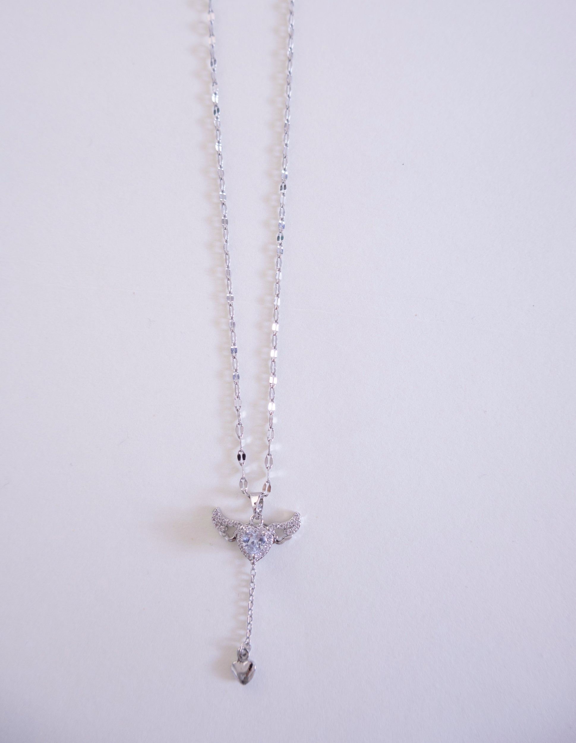 Silver necklace with a pendant on a light gray background