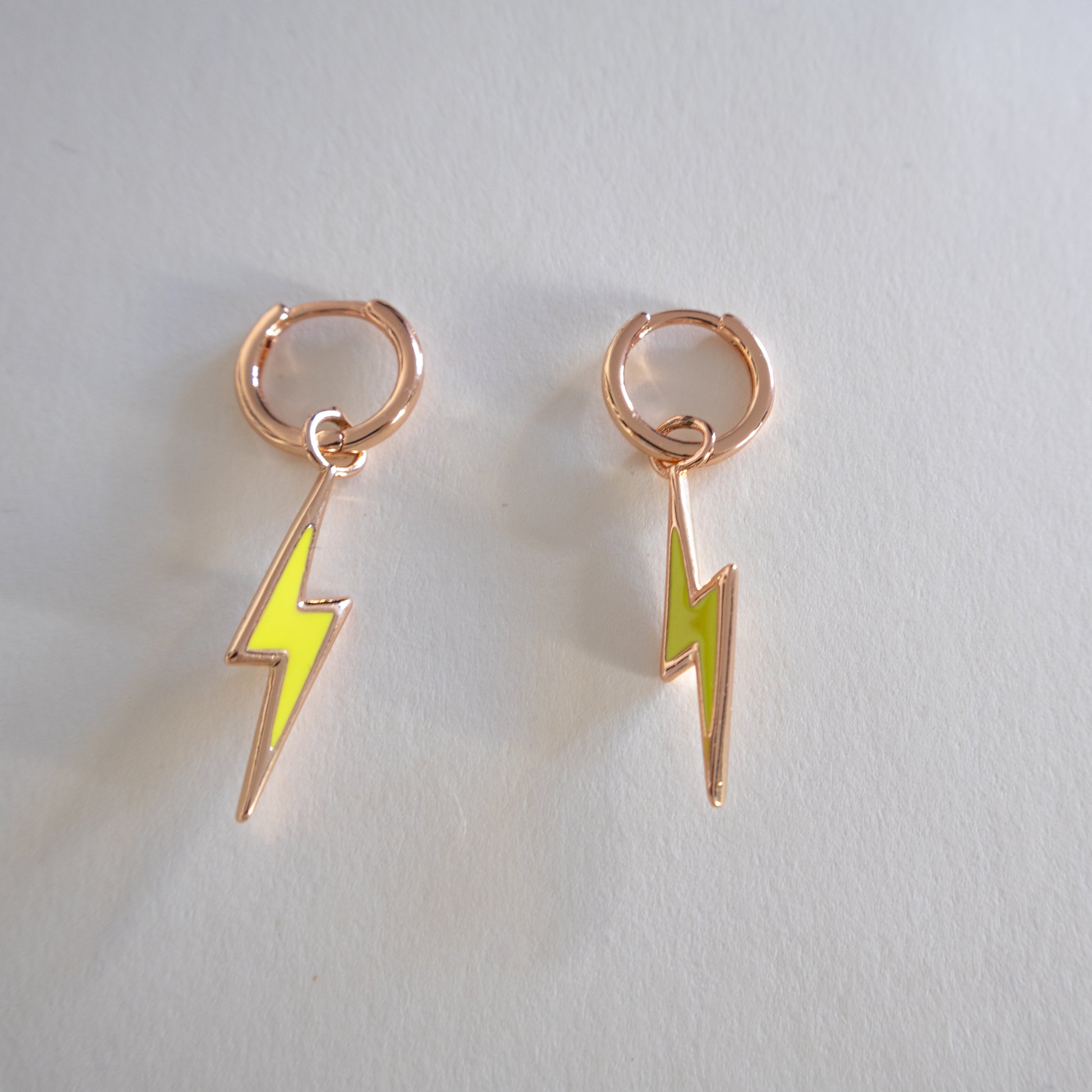 Pair of lightning bolt earrings on a light gray background
