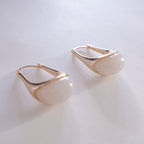 Gold hoop earrings on a light gray background