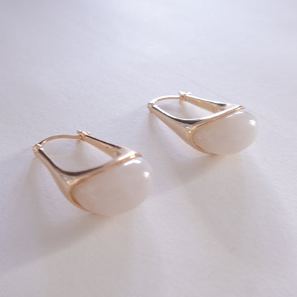 Gold hoop earrings on a light gray background