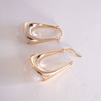Gold hoop earrings on a light gray background