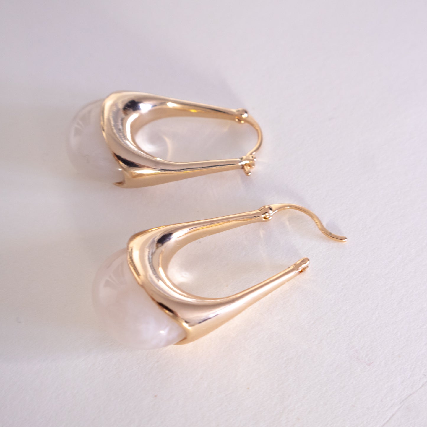 Gold hoop earrings on a light gray background